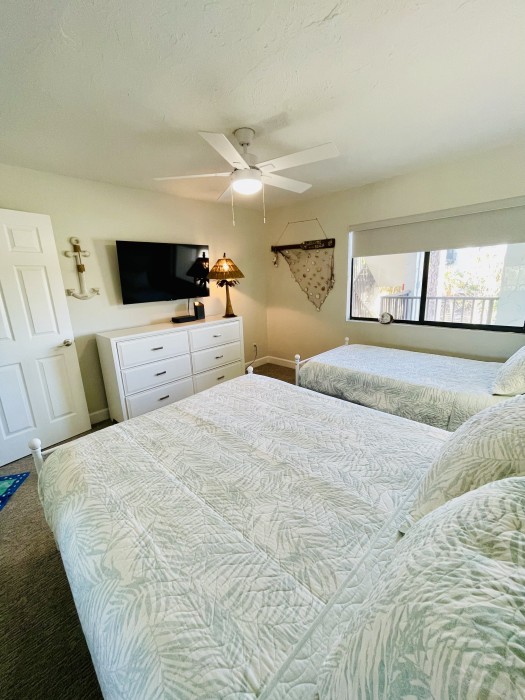 Queen and twin beds with a TV, books and toys, also with a full bathroom connected.